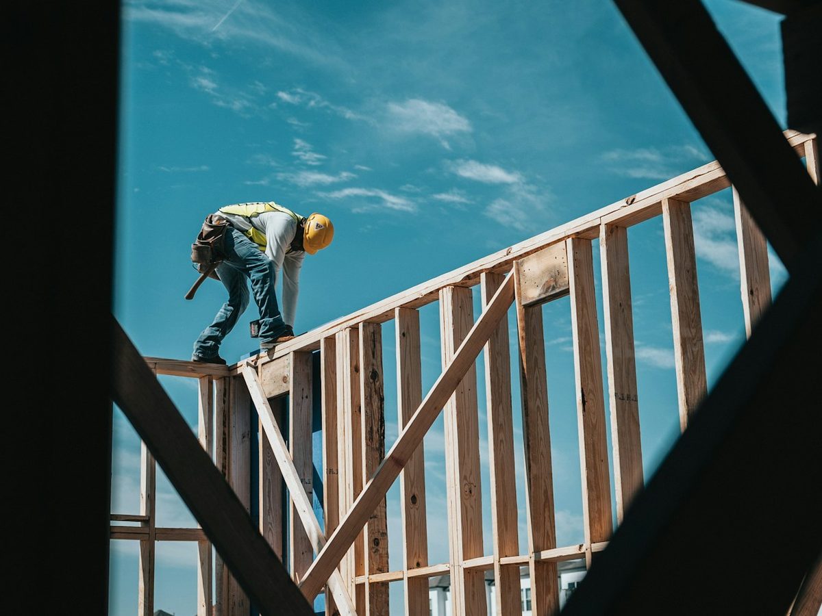 A builder framing the roof of a new home